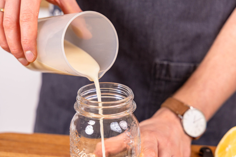 Hafermilch zu den Haferflocken gießen