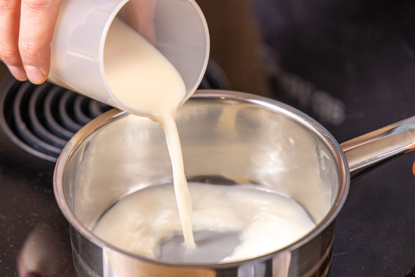 Milch in den Topf gießen
