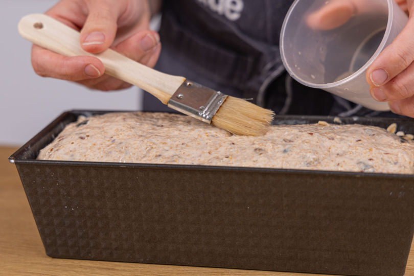 Körnerbrot mit Wasser einstreichen
