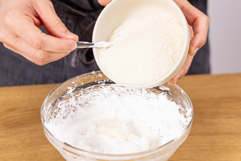 Kokosrapel unter Baisermasse heben