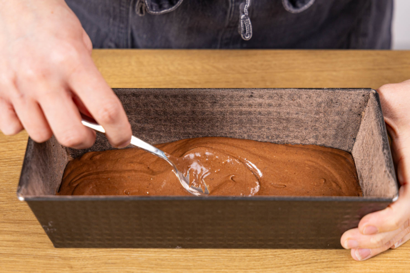 Teil des Schoko-Rührteig in die Backform geben