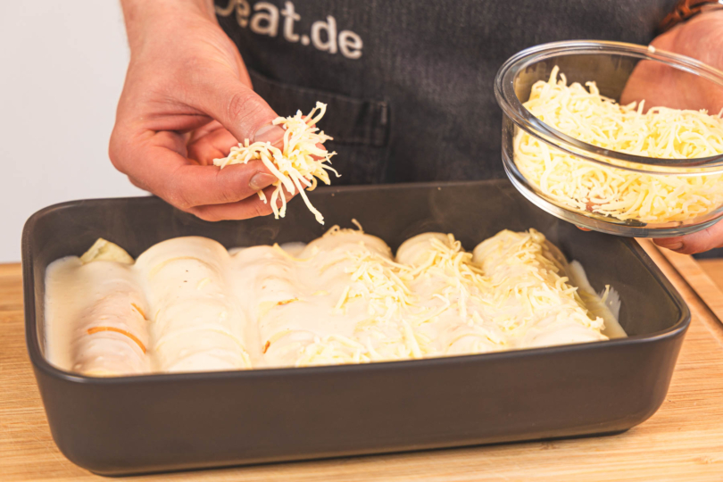 Pfannkuchenauflauf mit Käse bestreuen