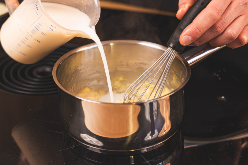 Milch zur Mehlschwitze gießen