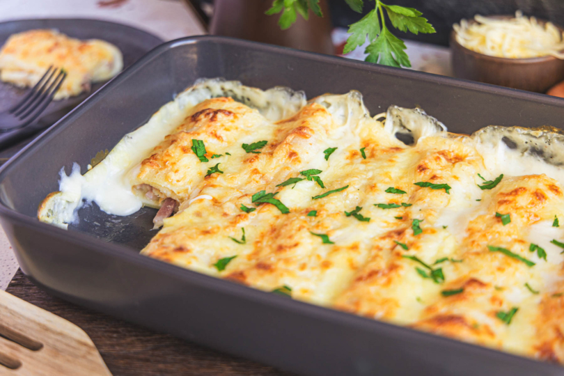 Überbackene Pfannkuchen mit Schinken und Käse in der Auflaufform nah