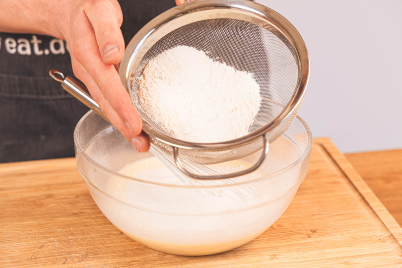 Mehl in den Teig sieben