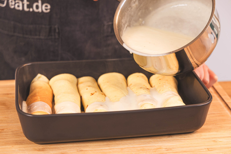 Sauce über die gefüllten Pfannkuchen geben