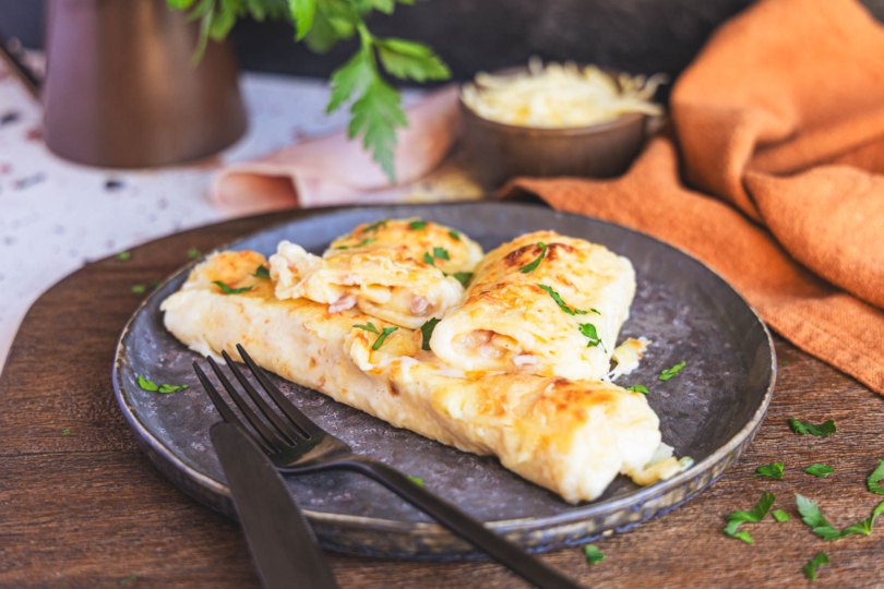 Überbackene Pfannkuchen mit Schinken und Käse auf dem Teller