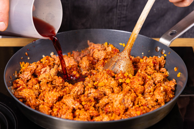 Traubensaft und gehackte Tomaten mit in die Pfanne geben