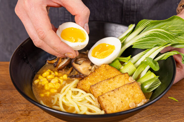 Vegetarische Ramen mit Ei garnieren