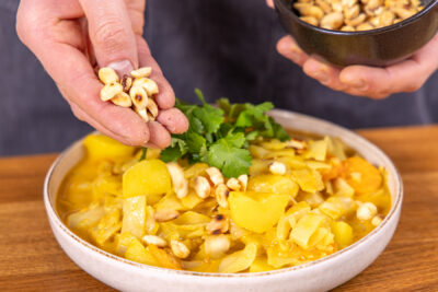 Weißkohlcurry mit Erdnüssen servieren