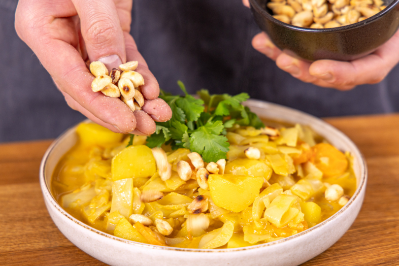 Weißkohlcurry mit Erdnüssen servieren