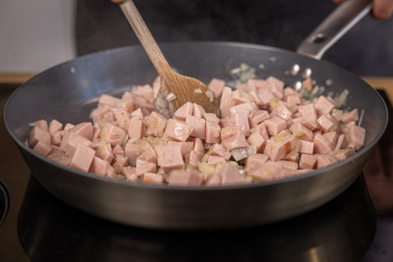 Zwiebeln und Fleischwurst in der Pfanne anschwitzen