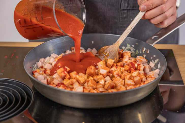 passierte Tomaten in die Pfanne geben