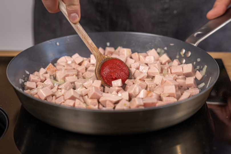 Tomatenmark in die Pfanne geben