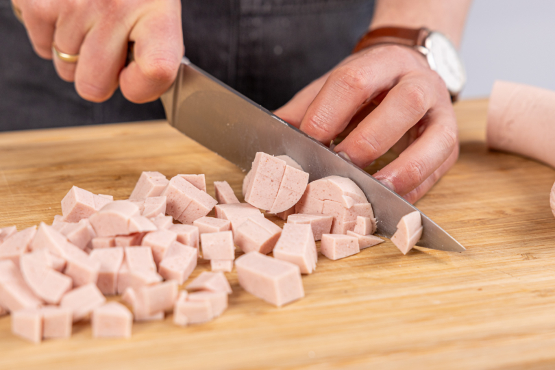 Fleischwürst in Würfel schneiden
