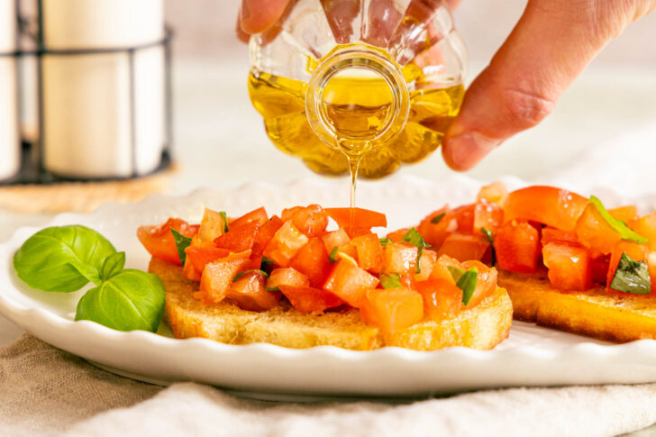 Bruschetta mit Öl beträufeln