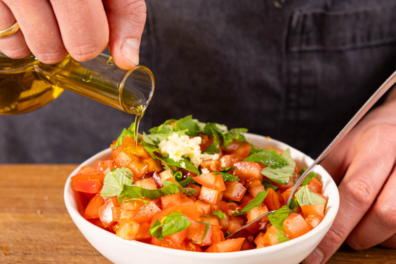 Öl zu den Tomaten geben und vermengen