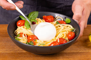 Burrata auf die Nudeln legen
