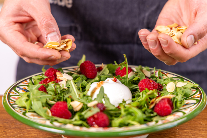 Burrata Salat mit gerösteten Mandeln garnieren