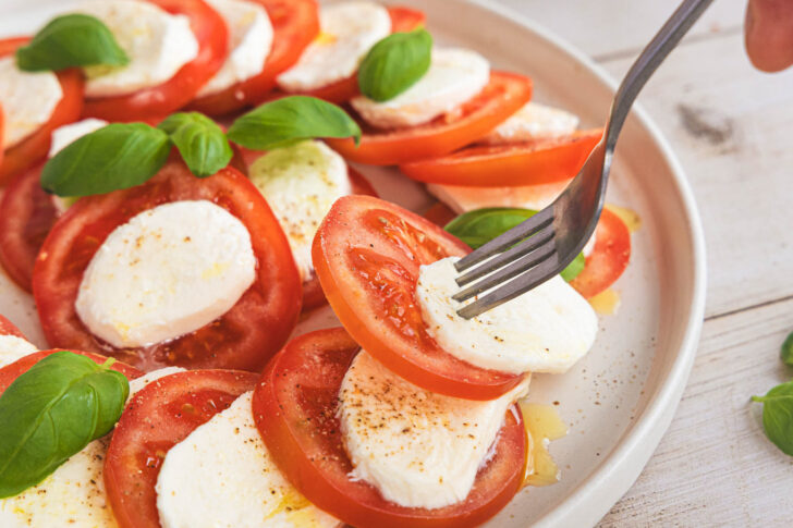 Caprese Salat mit Tomate und Mozzarella angabeln