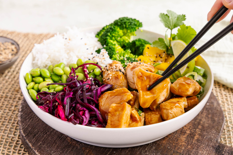 Chicken Bowl Teriyaki mit Stäbchen essen