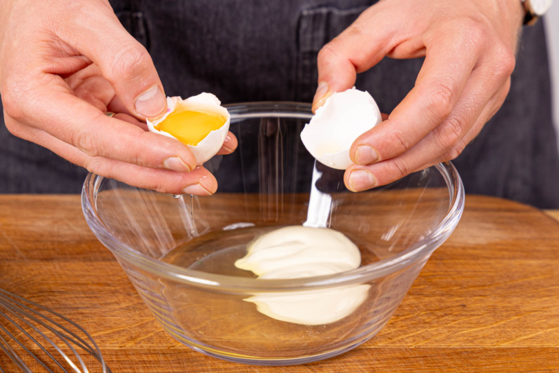 Mayonnaise und Ei in eine Schüssel geben