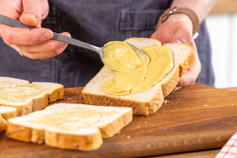 Brot mit Senf bestreichen