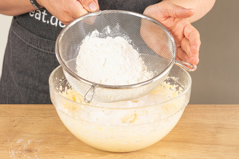 Mehl und Backpulver zum Teig sieben