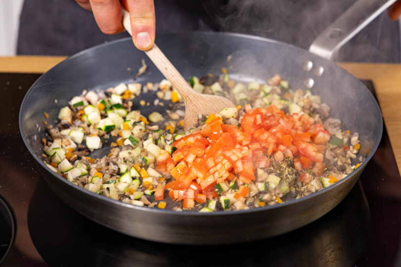 Tomaten unter das Gemüse rühren