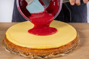 Himbeermasse über Cheesecake geben