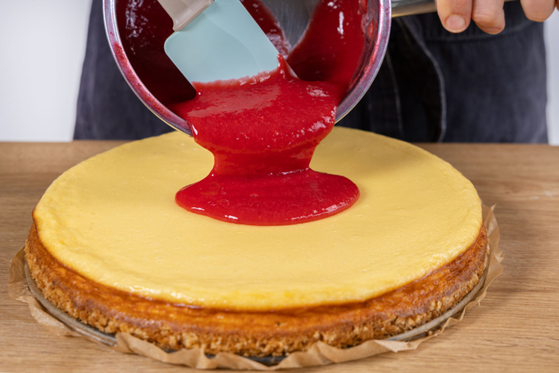 Himbeermasse über Cheesecake geben