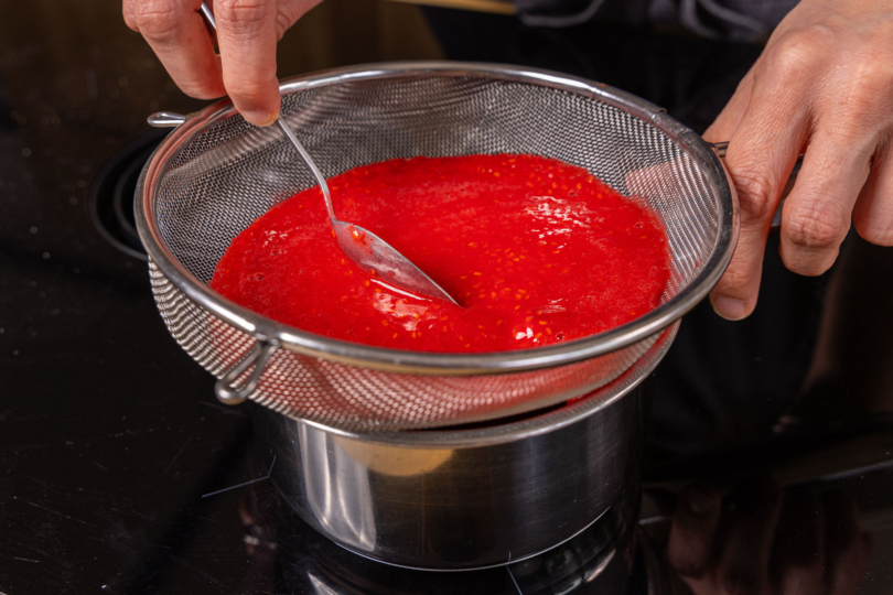 Himbeeren durch Sieb geben