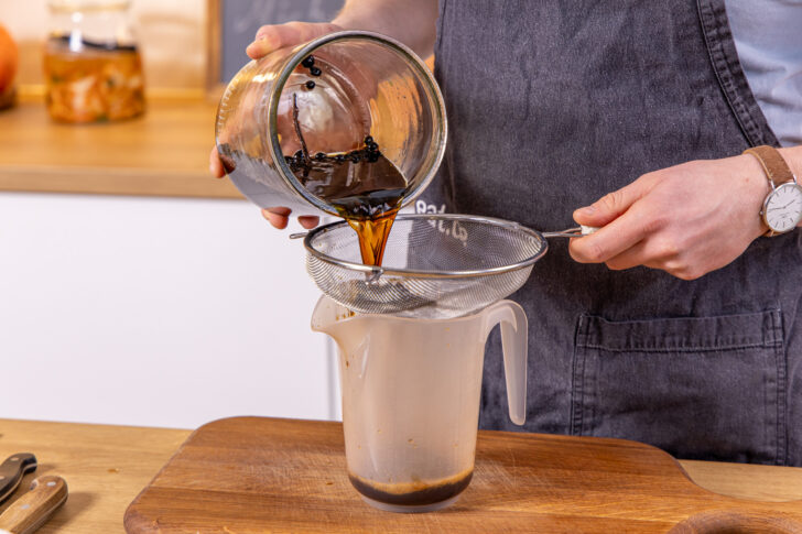 Kaffeelikör durch ein Sieb gießen