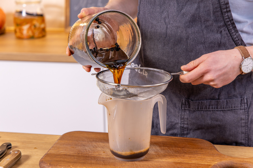 Kaffeelikör durch ein Sieb gießen