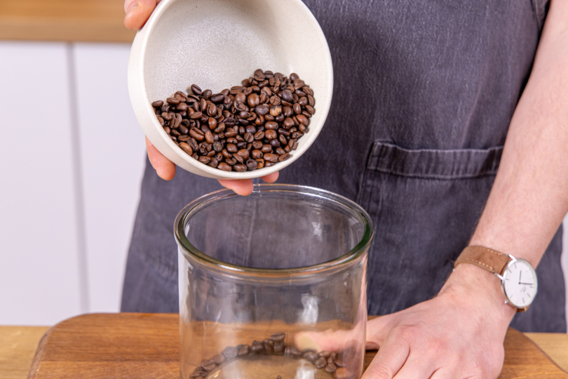 Kaffeebohnen in ein Glas geben
