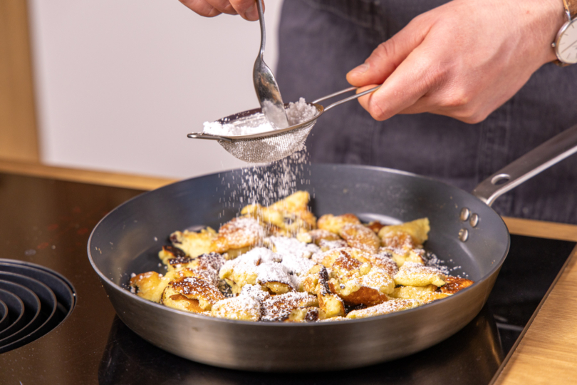 Kaiserschmarrn mit Puderzucker bestreuen