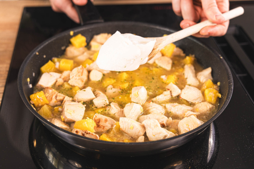 Kokosmilch zum Madras Chicken Curry mit Ananas geben