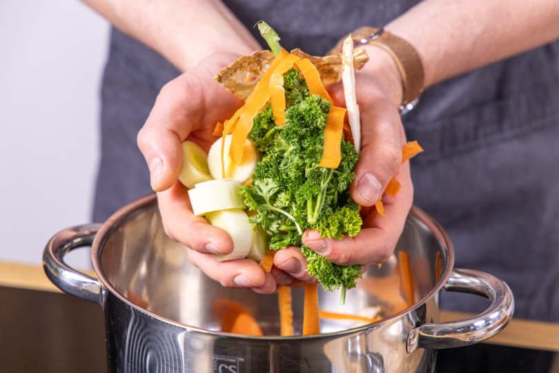 Gemüse in einen Topf geben