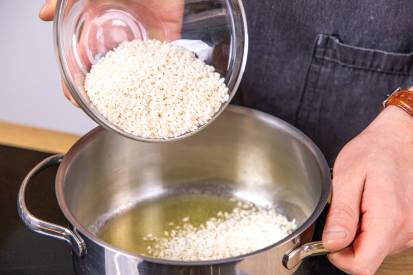 Risottoreis in den Topf geben