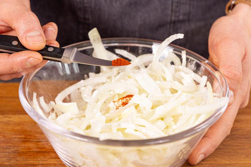 Mehl und Paprikapulver zu den Ringen geben