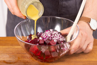 Dressing unter den Rote Bete Salat mischen