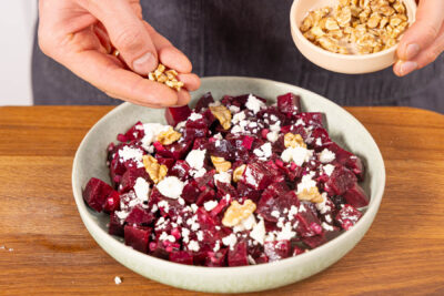 Rote Bete Salat mit Feat und Walnüssen garnieren