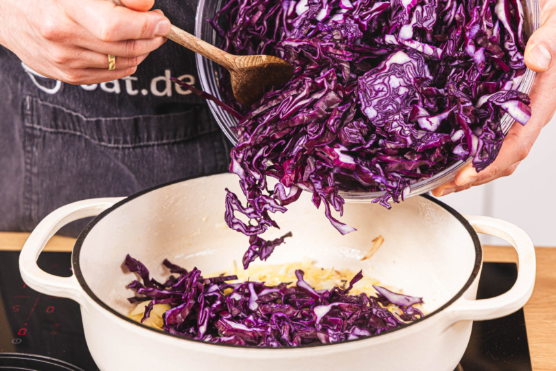 Rotkohl zu den Zwiebeln in den Bräter geben