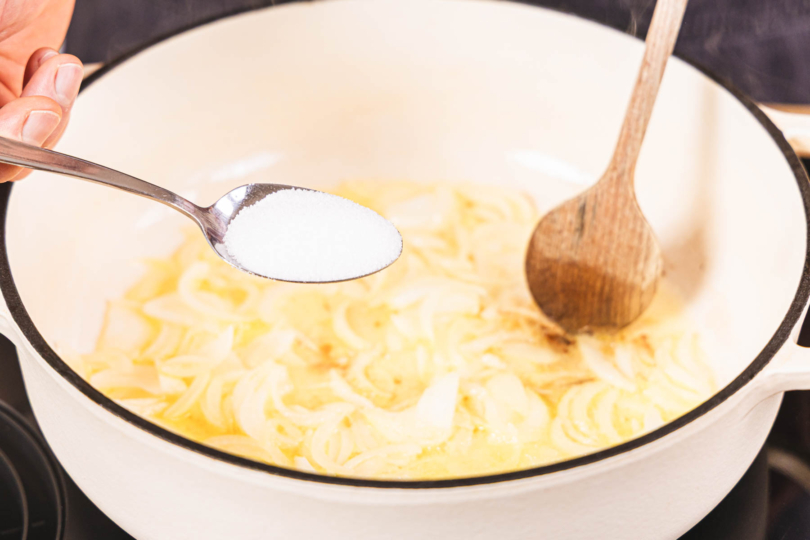 Zucker zu den Zwiebeln geben