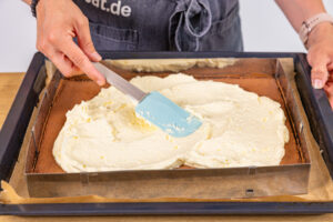 Buttercreme auf Kuchenboden verstreichen