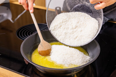 Kokos-Zucker-Mischung in geschmolzene Butter geben