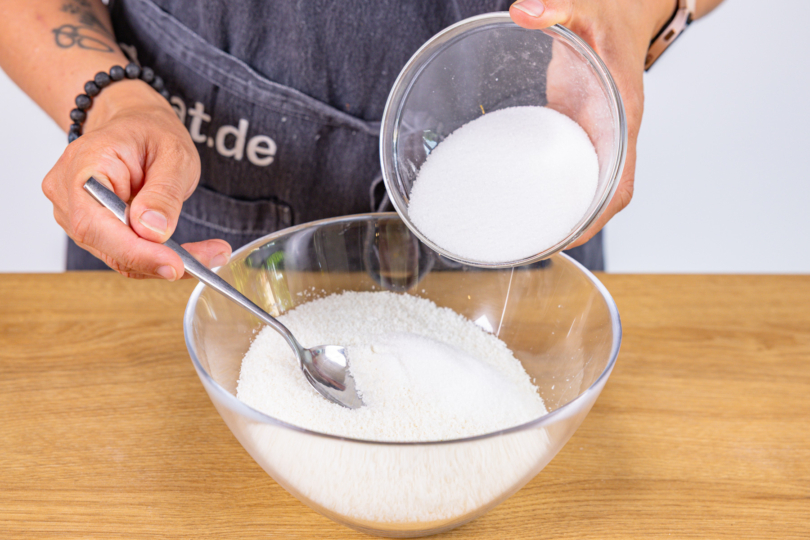 Kokosraspel und Zucker mischen