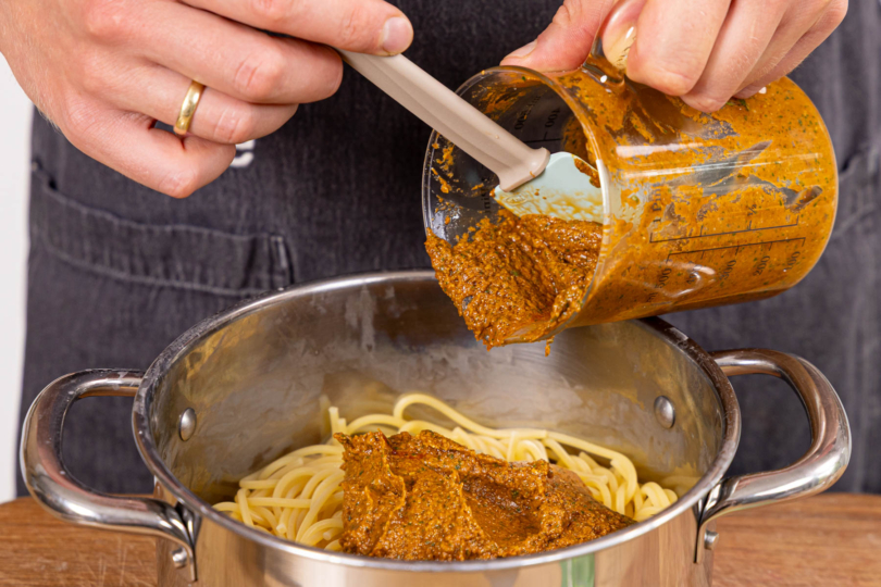 Soße und Nudeln vermengen