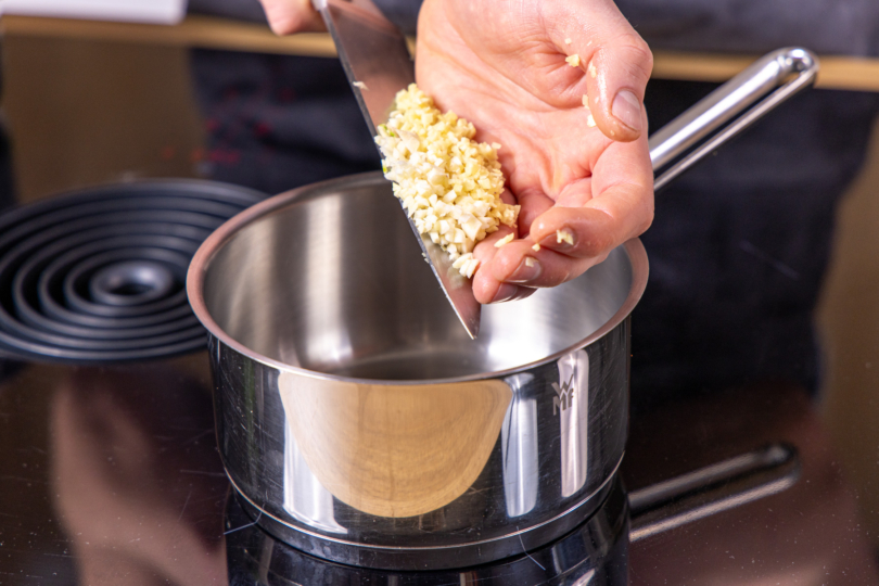 Knoblauch und Ingwer in einen Topf geben