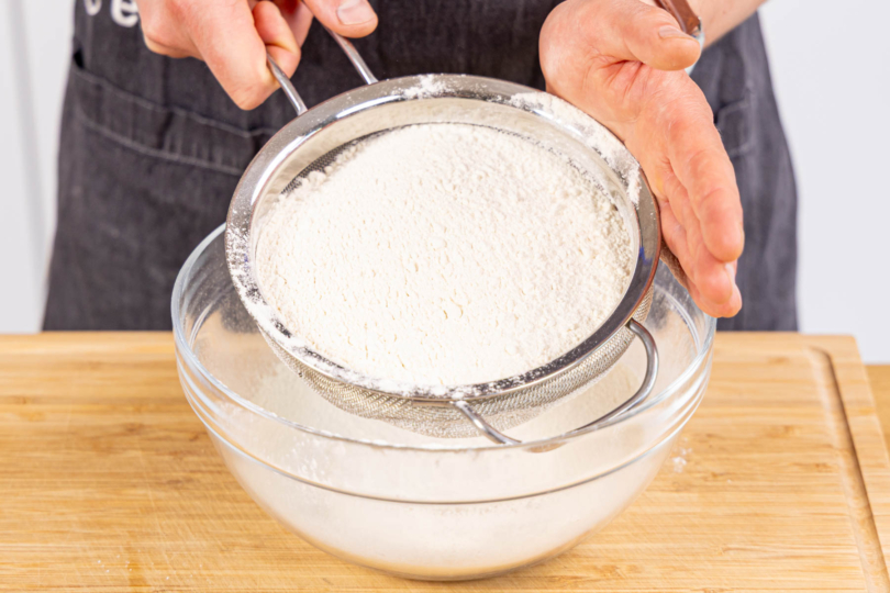 Mehl in eine Rührschüssel sieben
